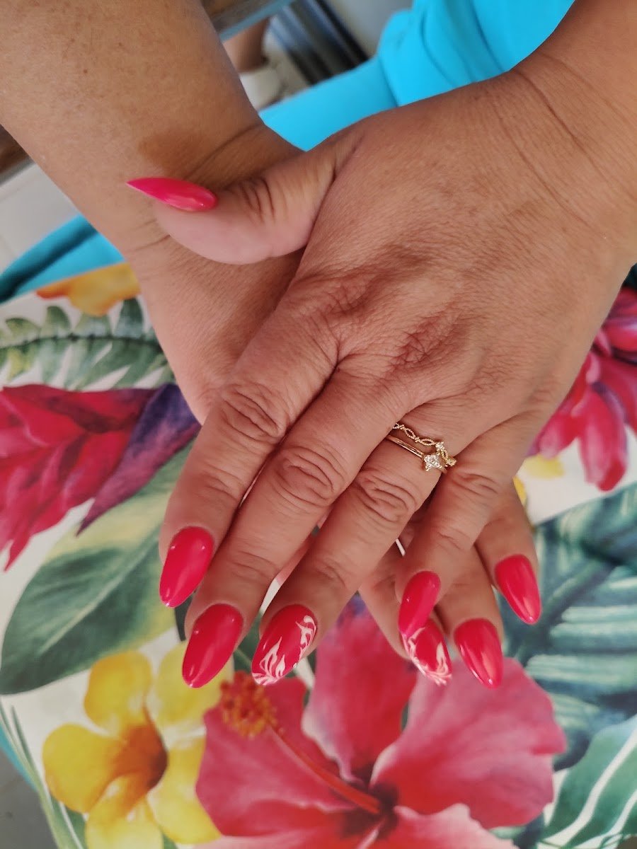 Manicura en fucsia sobre un mantel estampado de flores