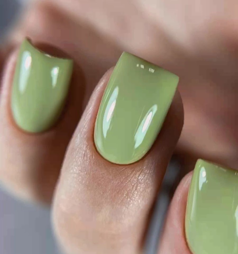 Uñas esmaltadas en verde salvia con brillo espejo